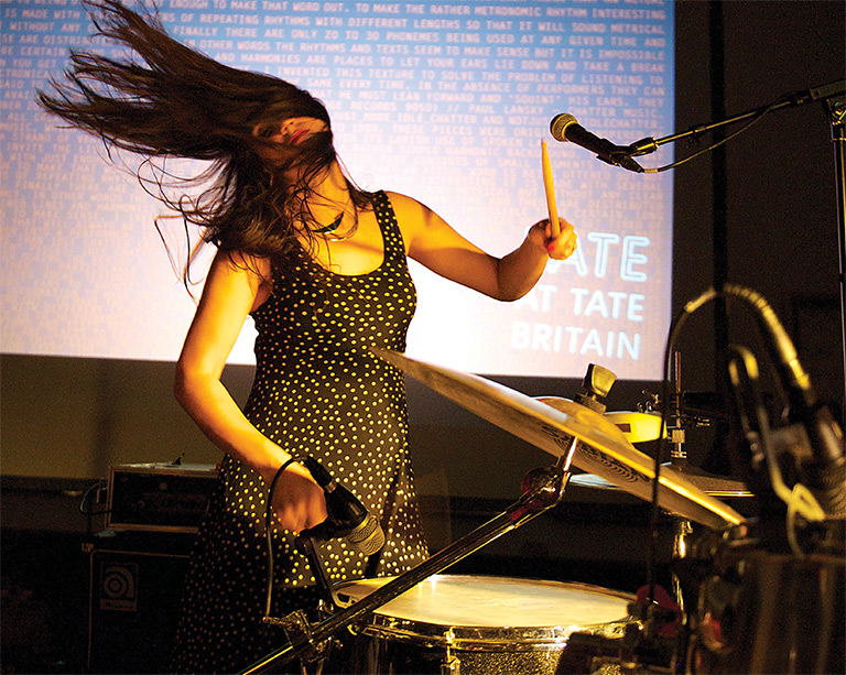Women playing the drums and flinging her hair around